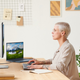 A photo of a person sitting at a desk and staring at the Dell monitor